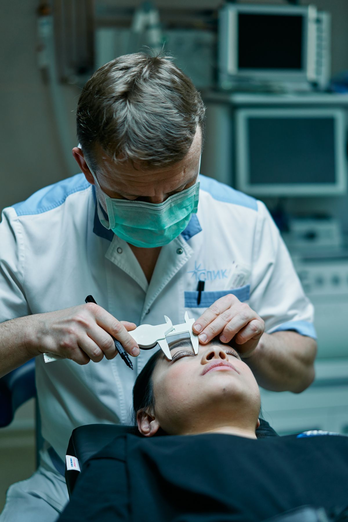 Surgeon measuring a patient's eyelid before treatment